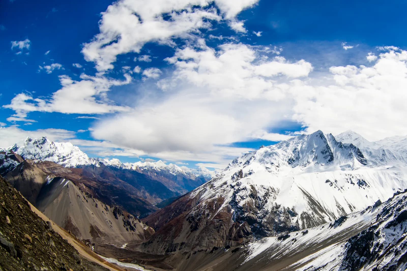 The Annapurna Circuit trail crossing open highland below the Annapurna range