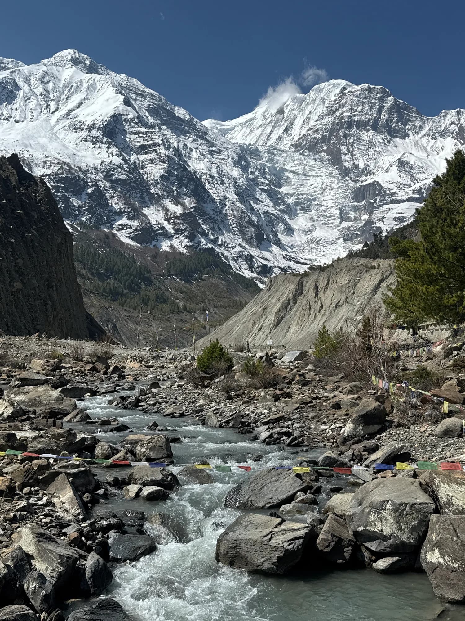 A rocky stream beneath snow-covered peaks in the Manang valley