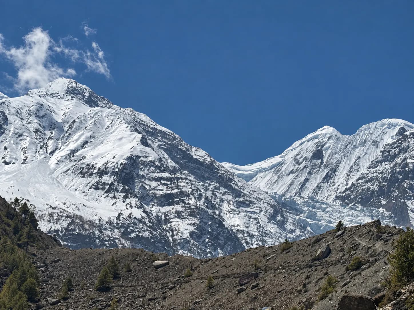 Snow-covered mountains above the rocky slopes of the Manang valley