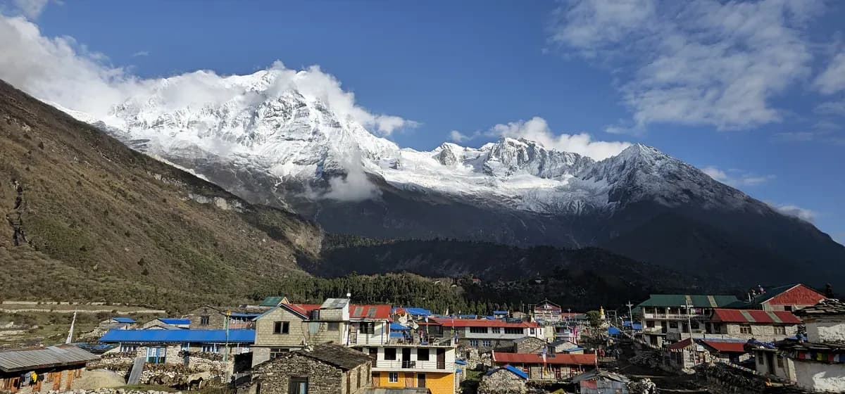 Samagaun village roofs beneath snow-covered mountain slopes on the Manaslu Circuit